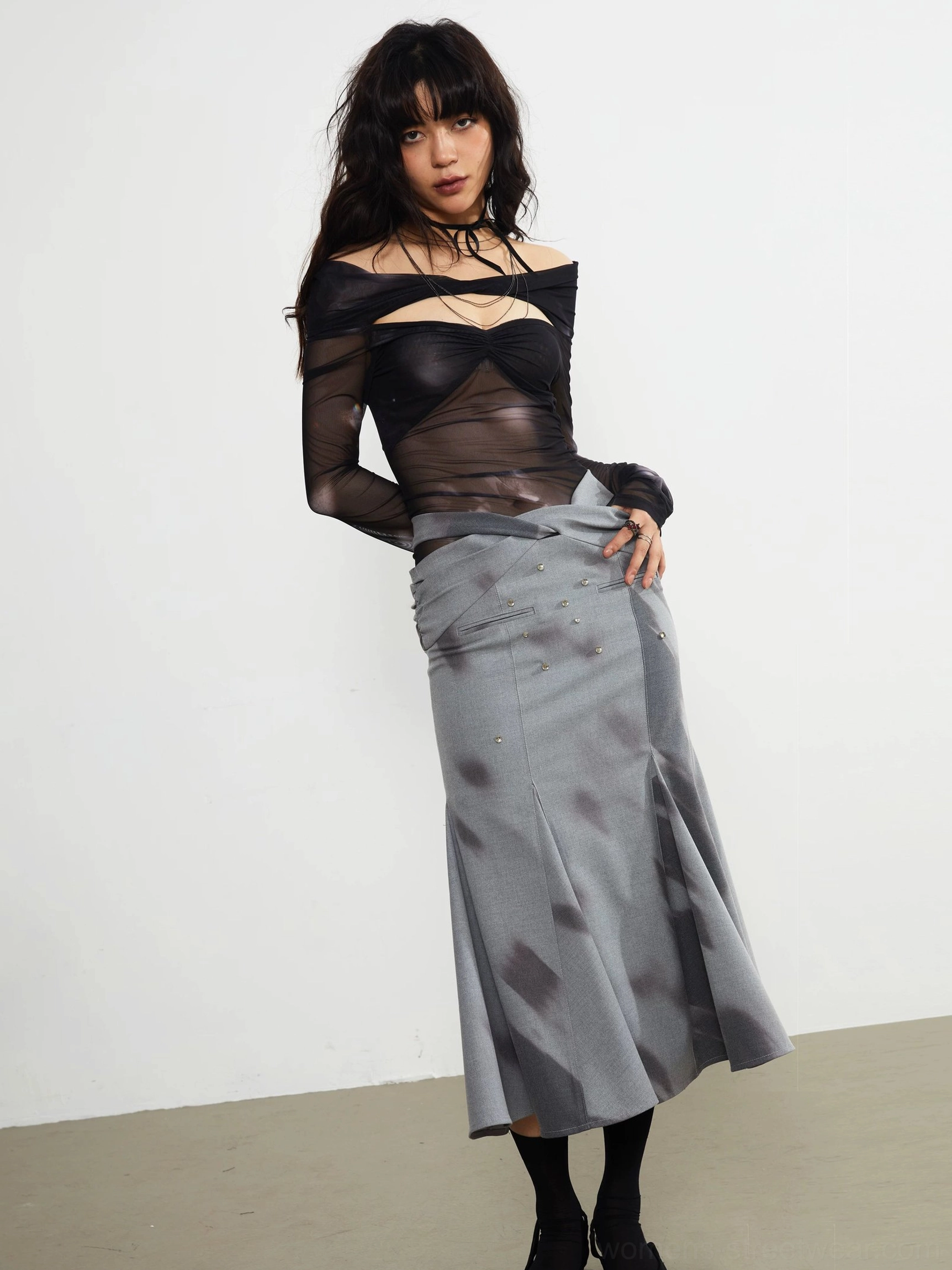 Gray embellished fishtail midi skirt with abstract dark watercolor print styled with a sheer black cropped top in a full front studio view