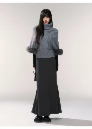 Gray faux fur cuff turtleneck cable knit sweater styled with a dark gray maxi skirt in a full body front studio look
