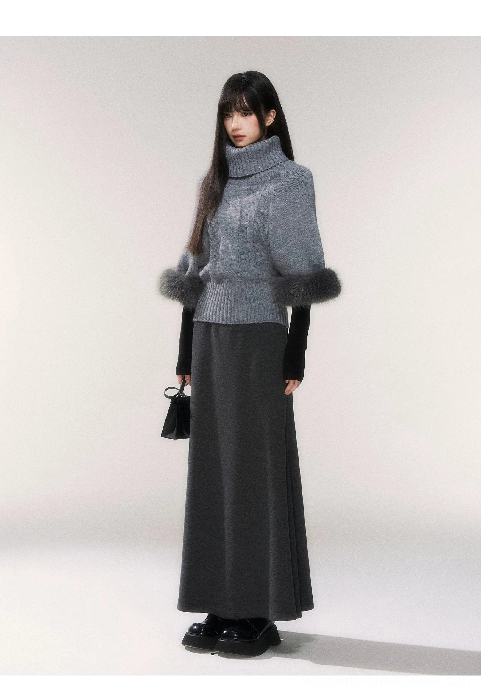 Side view of gray turtleneck cable knit sweater with plush faux fur cuffs and ribbed cropped hem