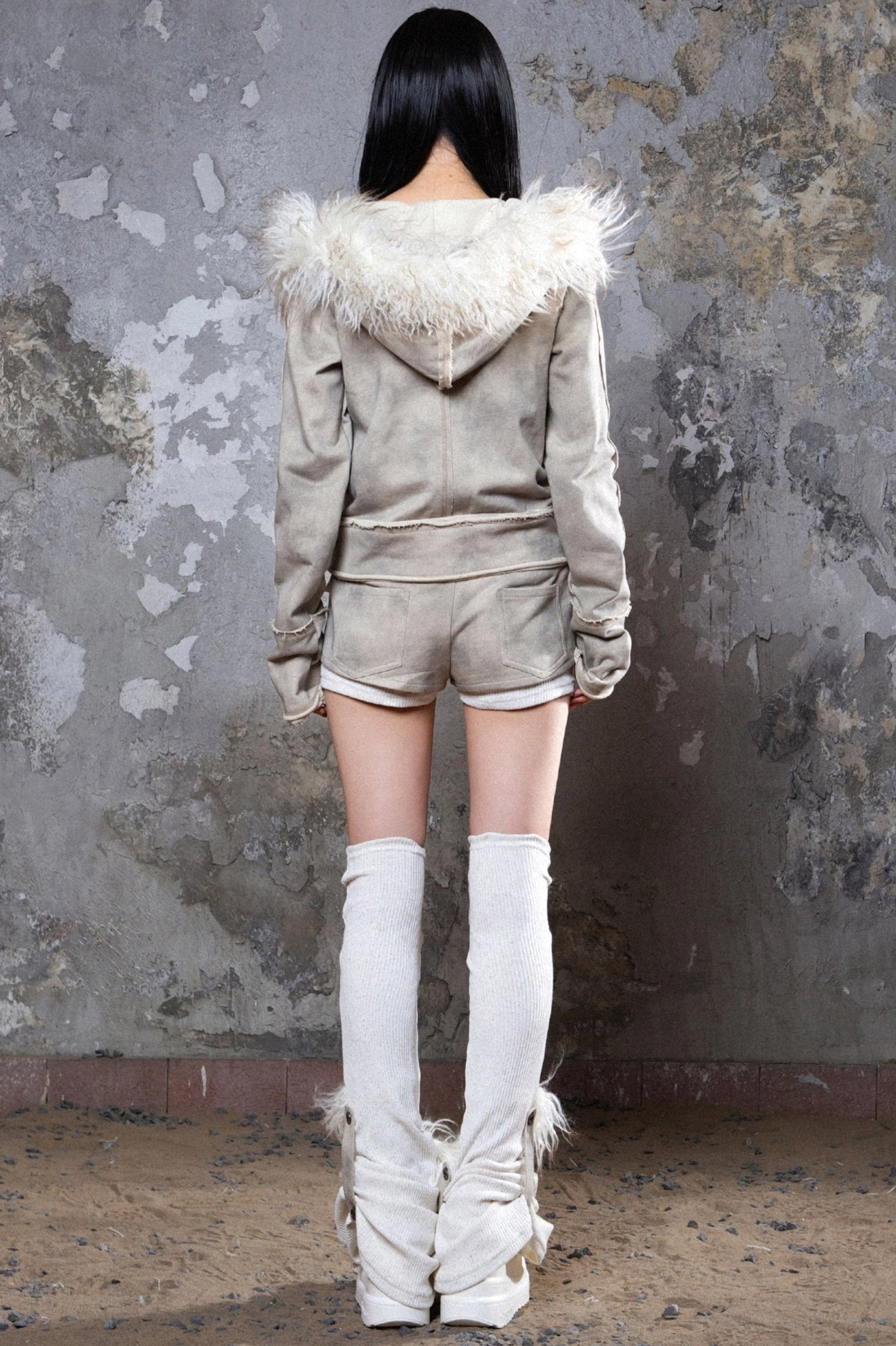 Gray faux fur hooded zip-up jacket featuring raw seam accents, neutral color, and versatile avant-garde streetwear appeal