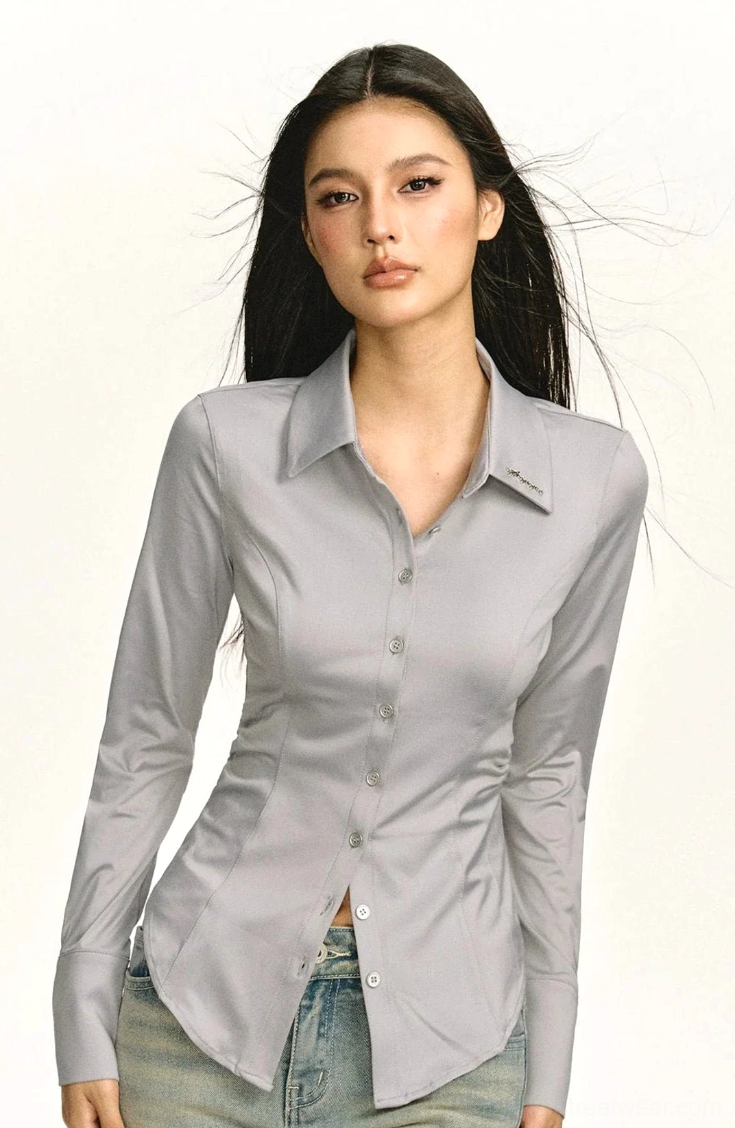 Gray fitted business shirt with pointed collar and button front styled with blue jeans