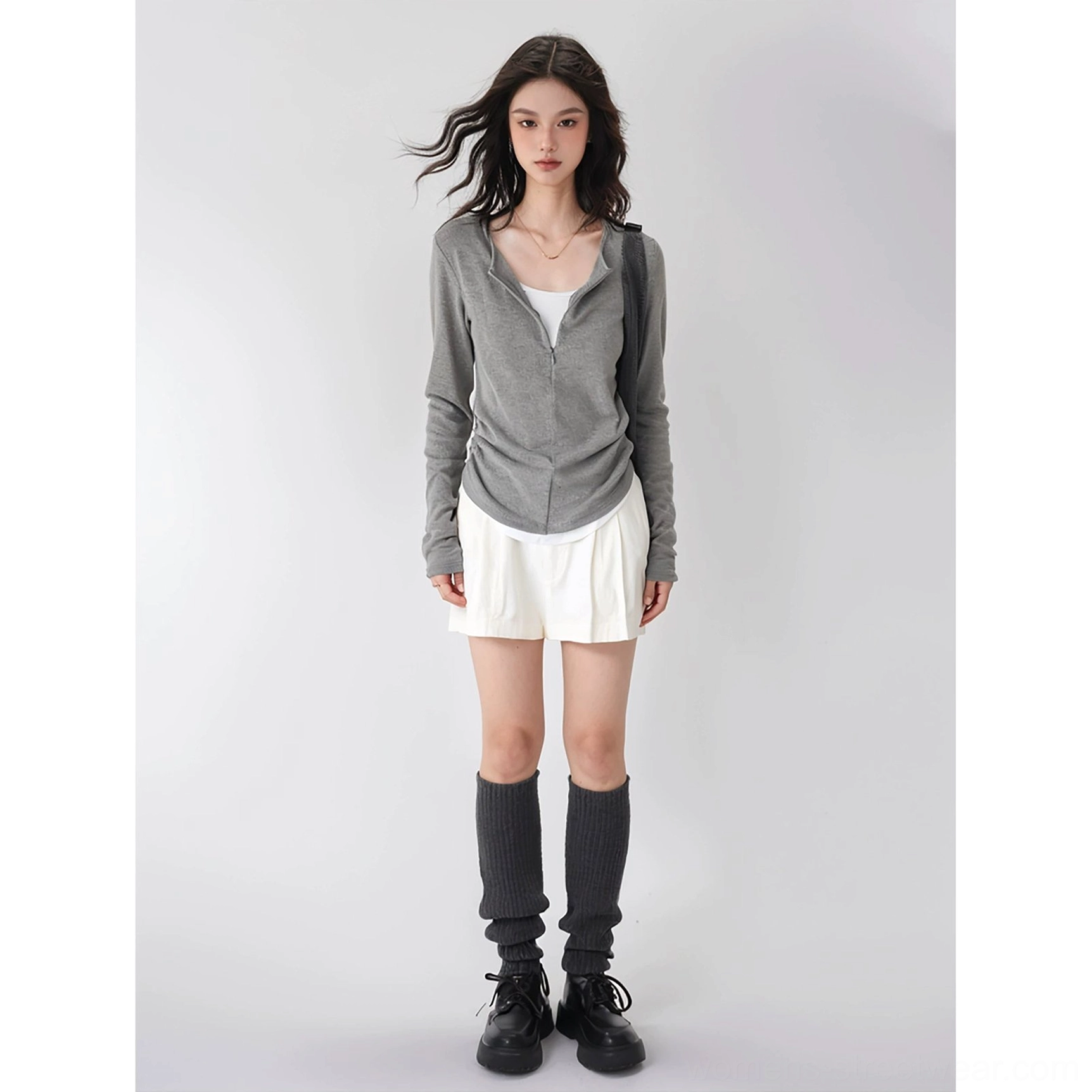 Gray fleece half-zip mock neck knit base layer top styled with white mini skirt leg warmers and black loafers