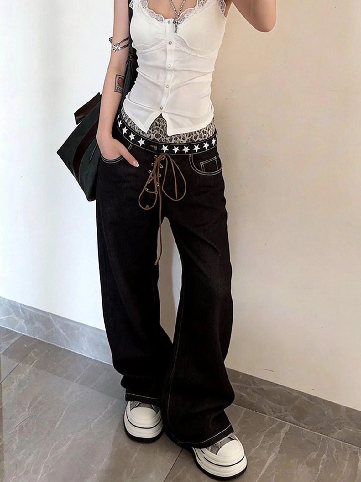 Female casual outfit with gray frayed canvas platform sneakers, black low-rise jeans, white camisole, and star-patterned belt
