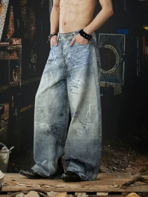 Front three quarter view of gray graffiti wide-leg jeans with faded denim wash, ultra baggy balloon silhouette, handwritten street art print, and extra-long stacked legs
