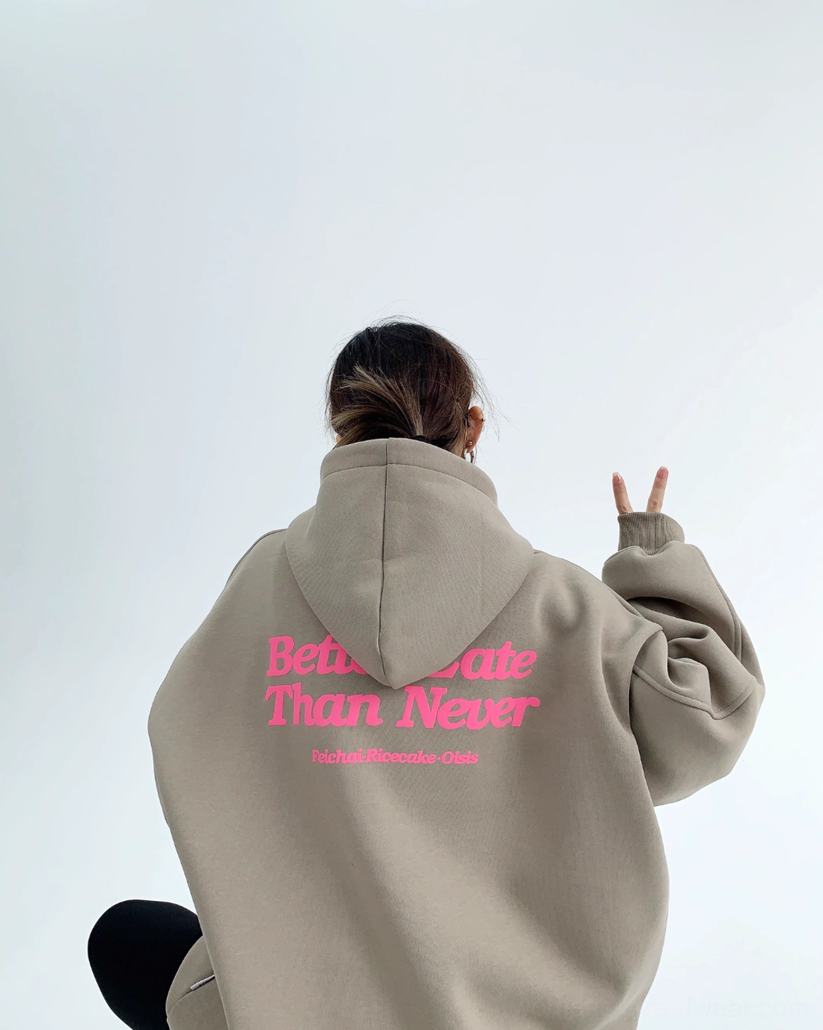 Gray green oversized pullover hoodie rear view with pink Better Late Than Never slogan attached hood and loose streetwear fit