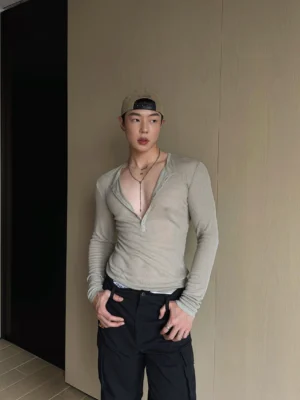 Front view of gray green slim fit ribbed Henley long sleeve top with deep button neckline and black cargo pants