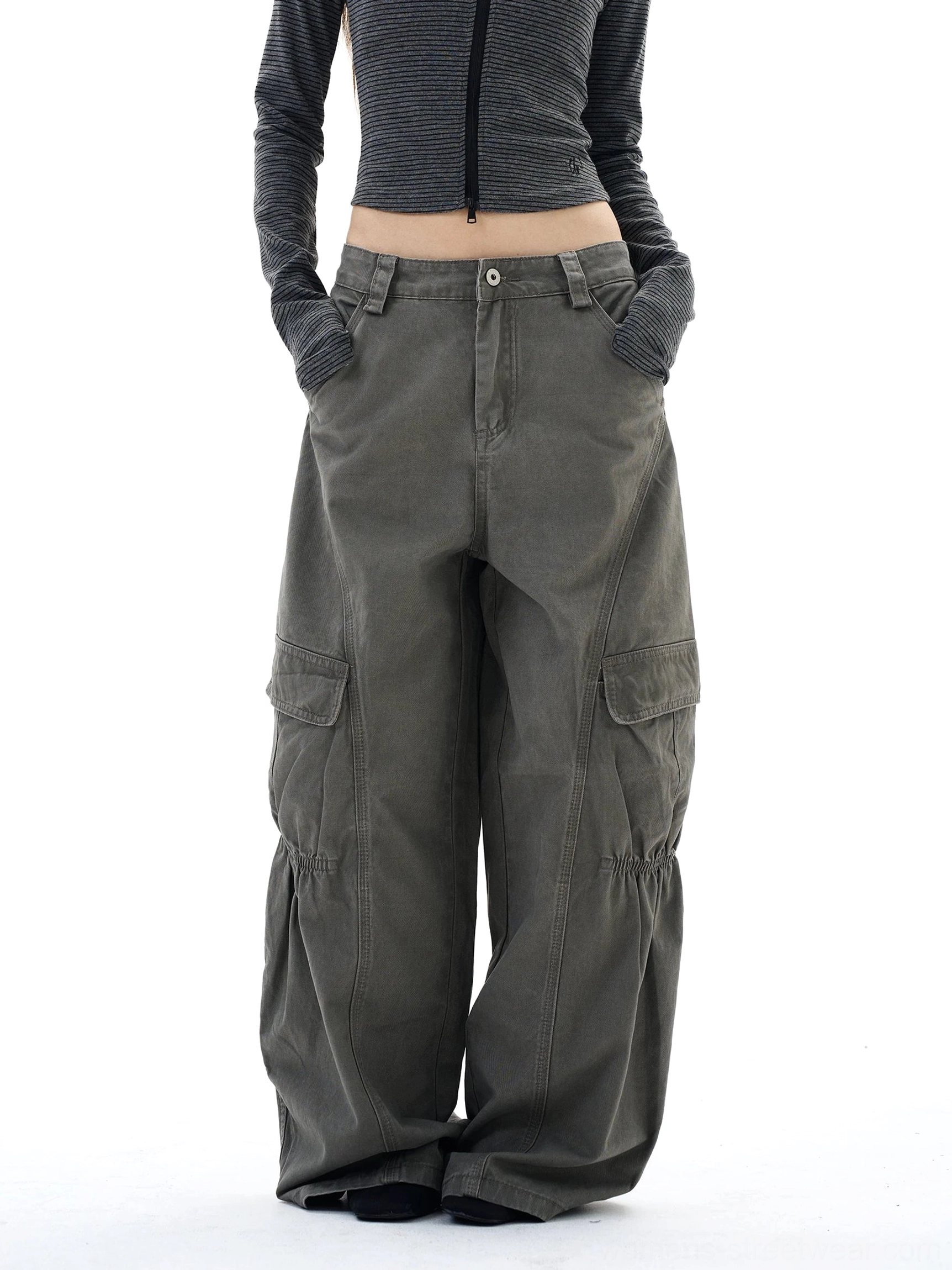 Full front view of wide-leg streetwear cargo pants in a neutral washed gray-green color with symmetrical side pockets