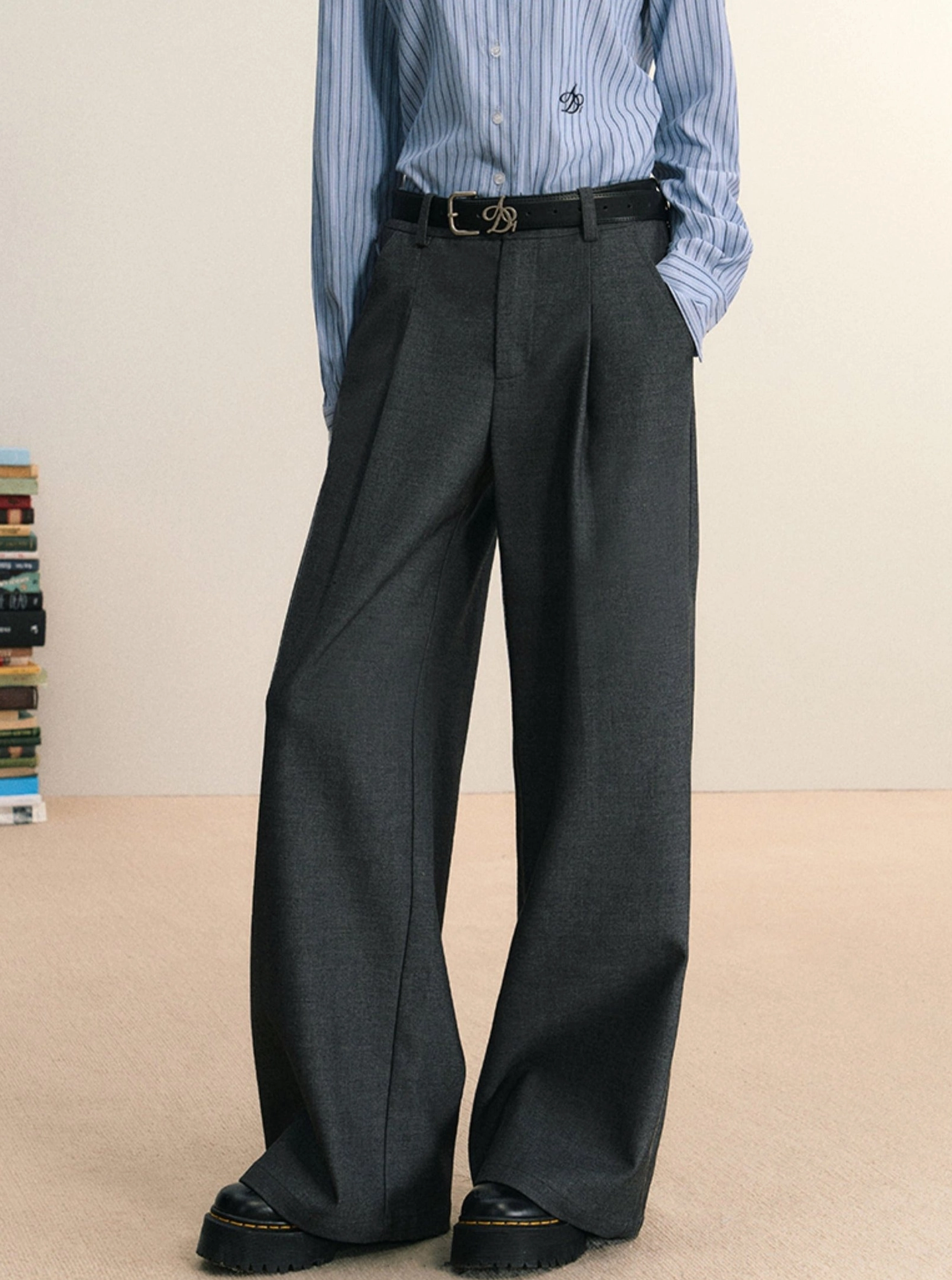 Gray high-waist pleated wide-leg streetwear trousers styled with a blue striped shirt and black buckle belt