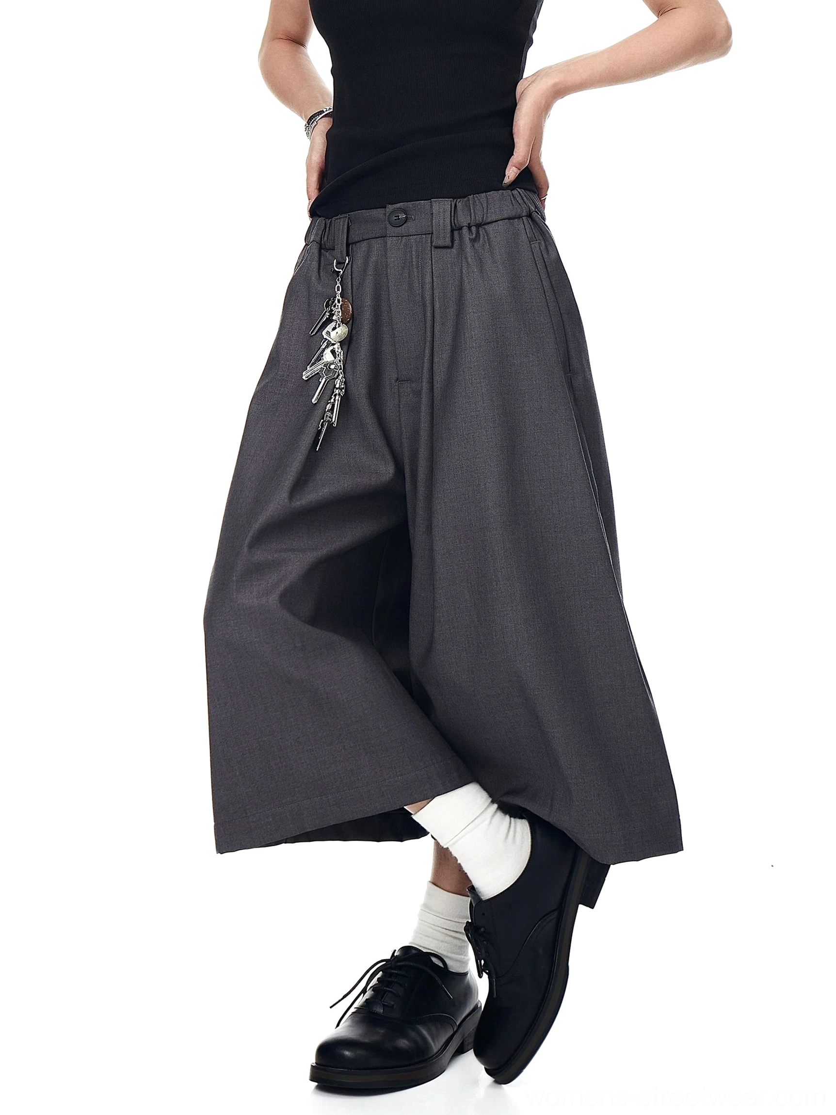 Gray keyring pleated culotte trousers shown from a low front three-quarter view with wide cropped legs and relaxed urban styling