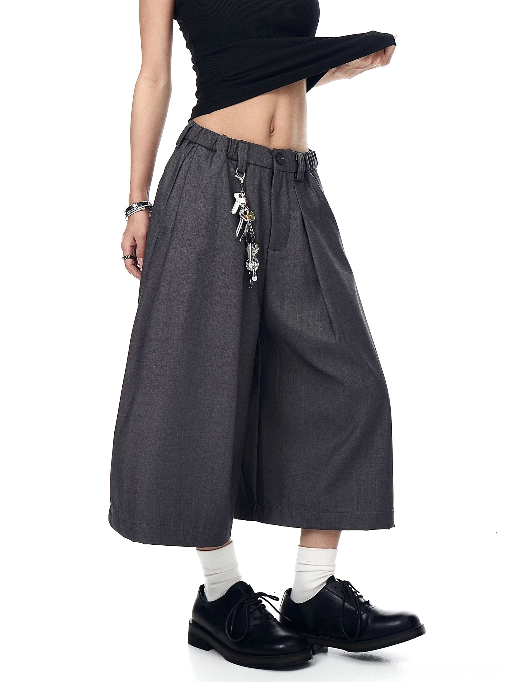 Gray keyring pleated wide-leg culotte trousers shown from a front three-quarter view with cropped hems, belt loops, and utility metal keychain detail