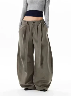 Front full-body view of gray khaki balloon trousers with ultra-wide streetwear legs, front pleats, detachable waist straps, button fly, and dramatic oversized drape