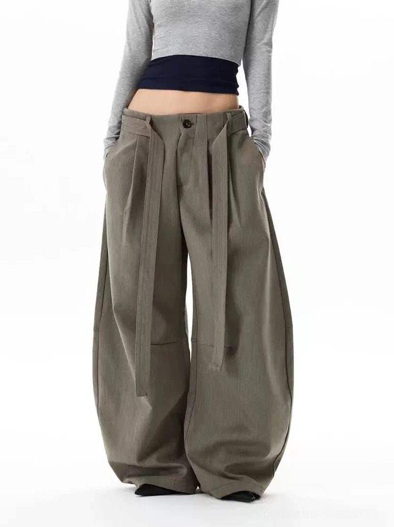 Front full-body view of gray khaki balloon trousers with ultra-wide streetwear legs, front pleats, detachable waist straps, button fly, and dramatic oversized drape