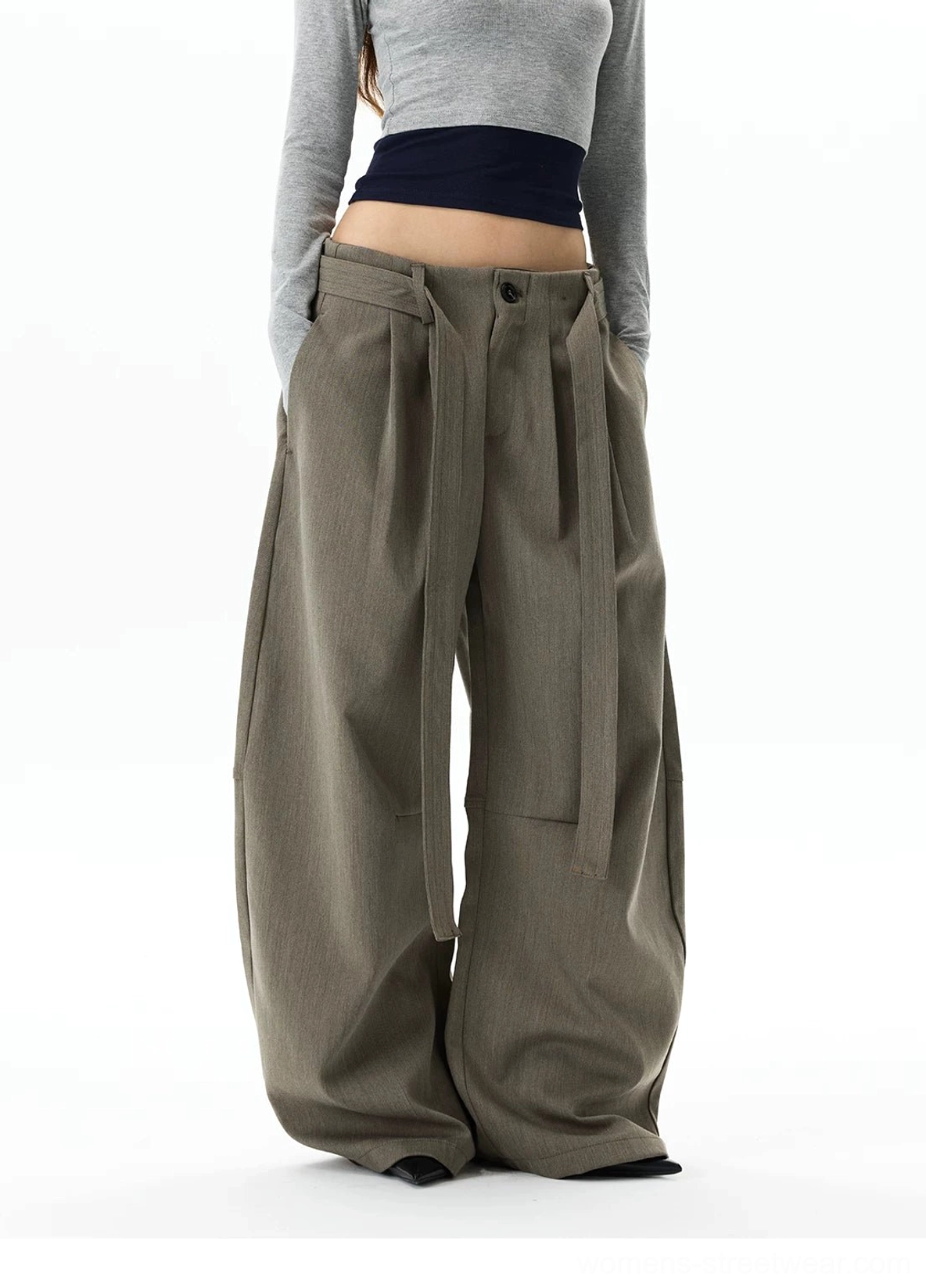 Front three-quarter view of gray khaki balloon trousers with sharp waist pleats, integrated belt straps, and soft relaxed fabric drape