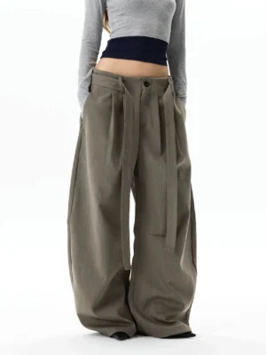 Back three-quarter view of oversized gray khaki wide leg trousers showing the structured waistband, full balloon silhouette, and relaxed streetwear drape