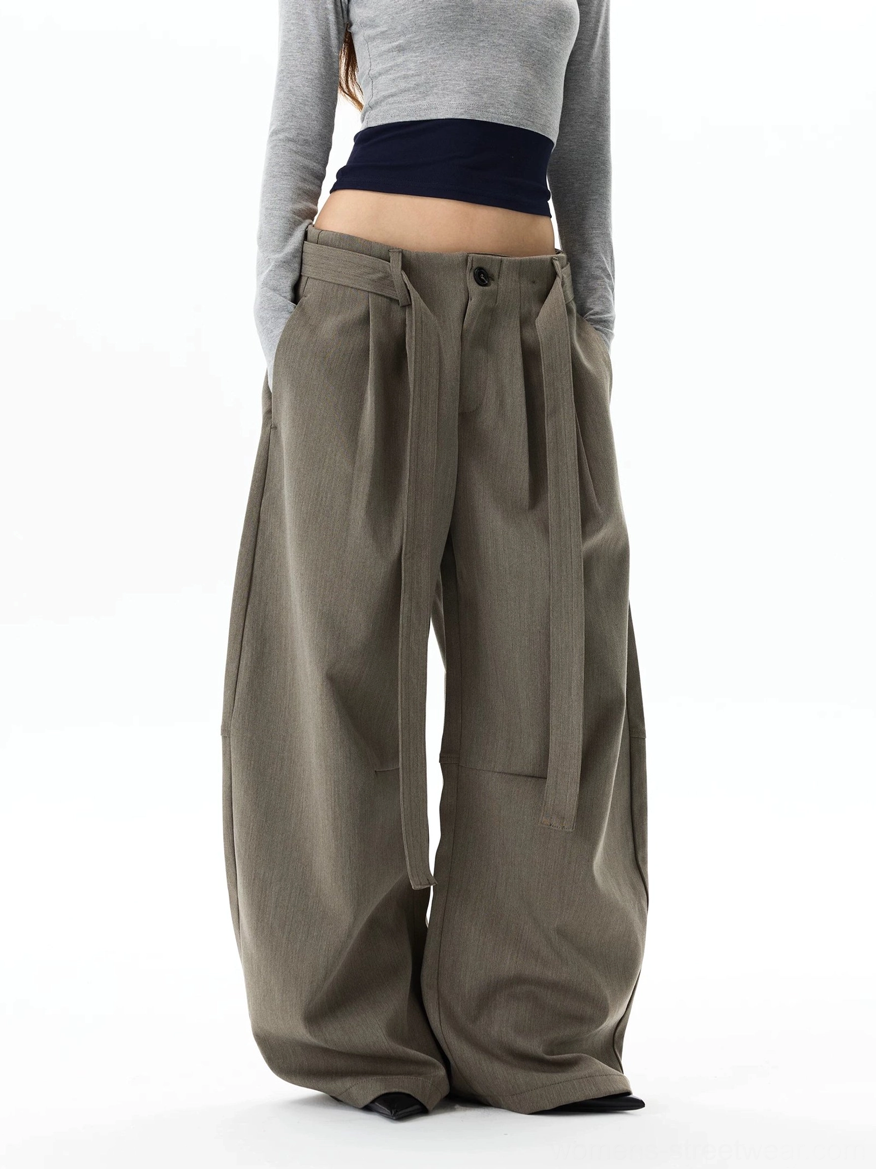 Back three-quarter view of oversized gray khaki wide leg trousers showing the structured waistband, full balloon silhouette, and relaxed streetwear drape
