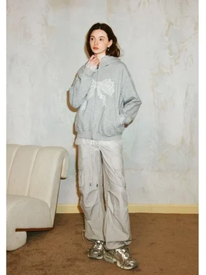 Front view of a gray lace bow zip-up hoodie with white bow motif, relaxed fit, front zipper, and Korean streetwear styling