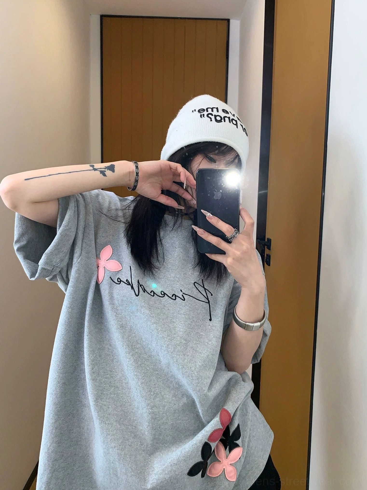 Woman wearing a heather gray oversized script floral graphic tee with pink and black flower motifs in a relaxed Korean fashion outfit