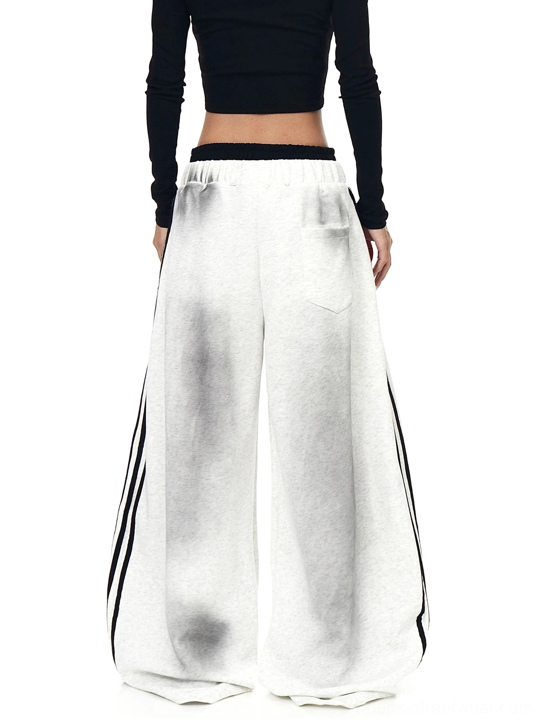 Back view of heather gray oversized wide-leg fleece sweatpants showing faded wash effect, elastic waist, and full-length side stripes