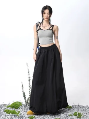 Light gray padded double spaghetti strap cropped camisole tank top styled with a high waisted black wide leg maxi skirt in a minimalist streetwear studio