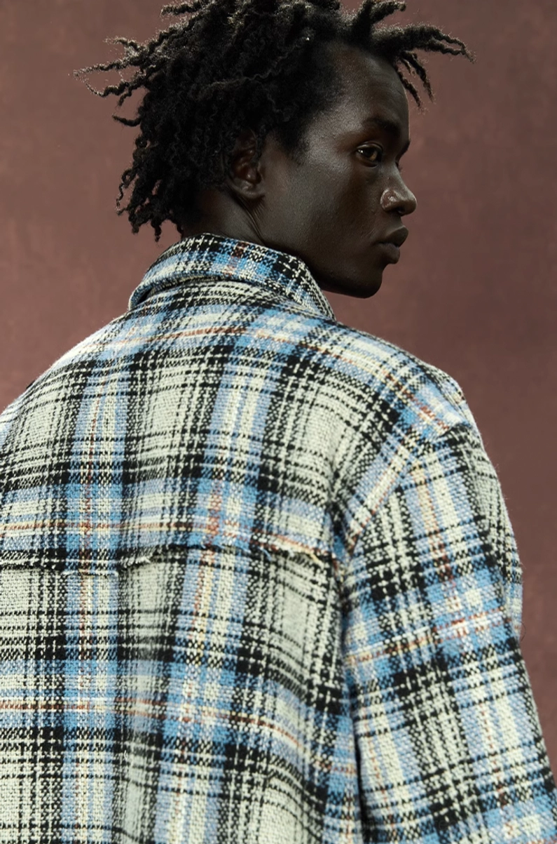 Close back view highlighting the woven tartan plaid pattern and relaxed construction of the gray shirt jacket