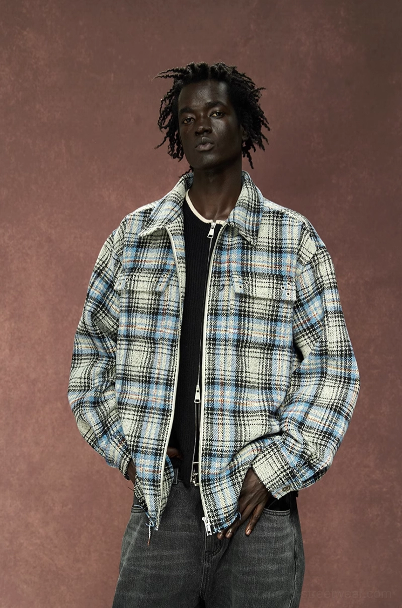 Male model wearing an oversized gray plaid shirt jacket with black tee and dark denim in a contemporary streetwear outfit