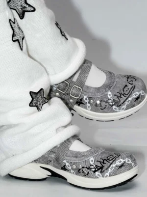 Gray punk Mary Jane sneakers with double buckle straps and pearl details styled with star embroidered knit trousers and white ankle socks