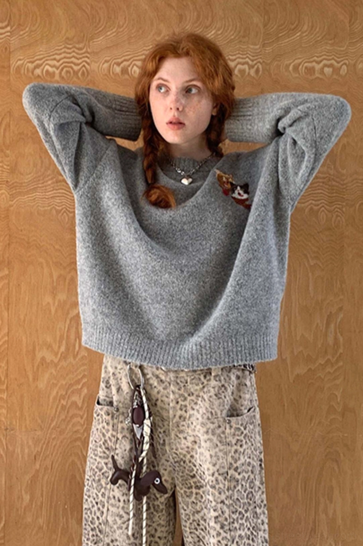 Three-quarter back view of gray relaxed cat knit sweater with soft texture and loose streetwear fit