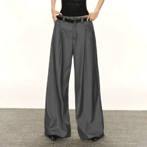Gray retro wide-leg tailored streetwear trousers shown from the front with high-rise pleated waist, belt loops, flowing suiting fabric, and full-length relaxed silhouette