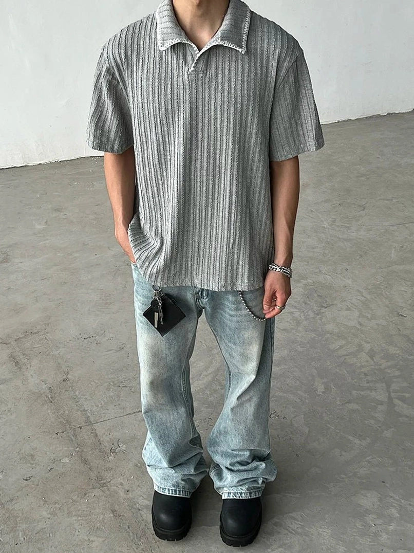 Full body outfit featuring a gray textured ribbed knit polo shirt with baggy light wash jeans and black leather shoes