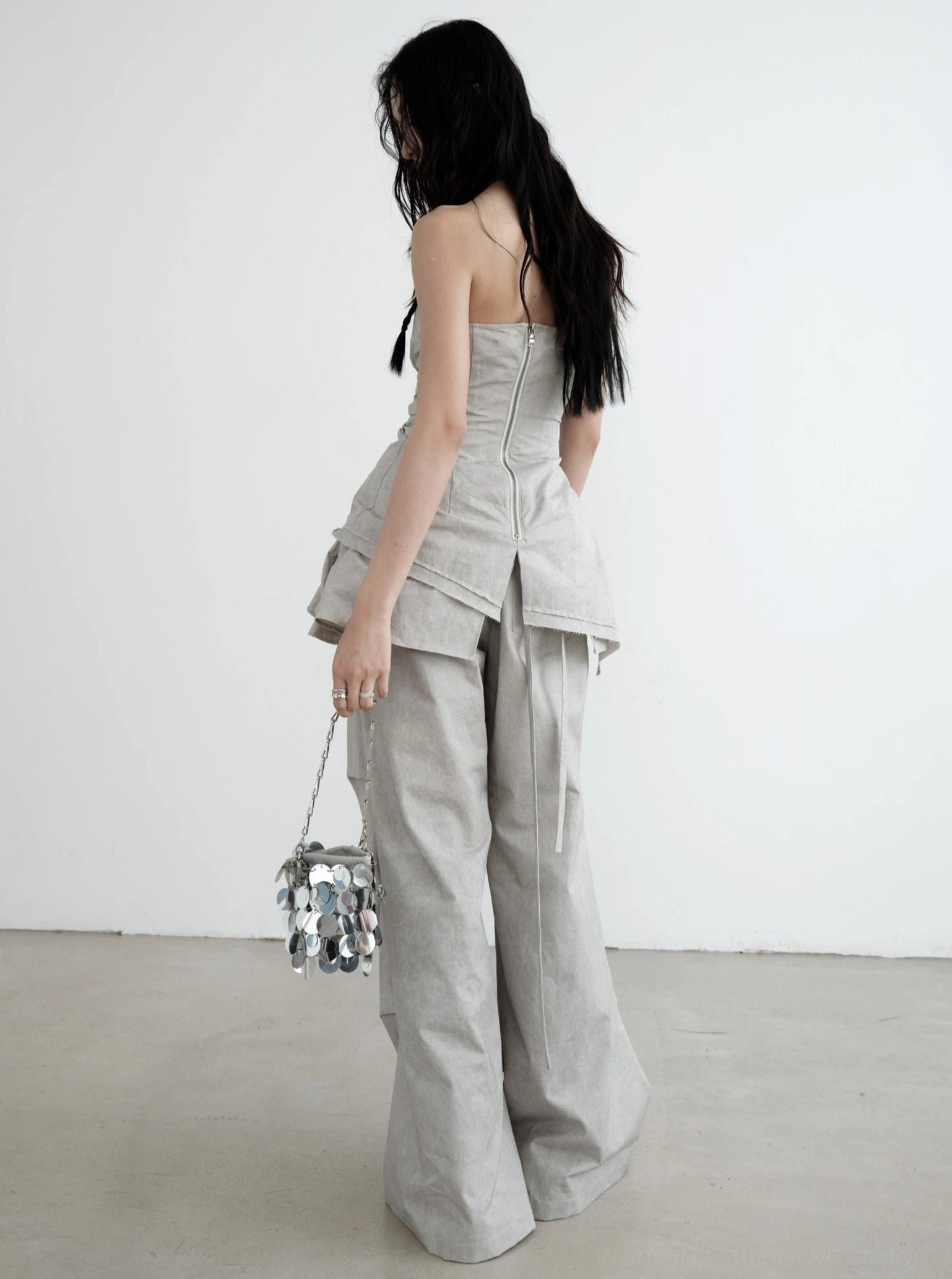 Back view of gray ruffled palazzo cargo pants with layered waist detail and flowing wide-leg silhouette styled for Seoul fashion