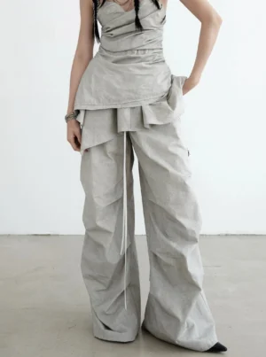 Front view of gray ruffled palazzo cargo pants with drawstring waist, oversized wide legs, crinkled folds, and contemporary Y2K streetwear styling