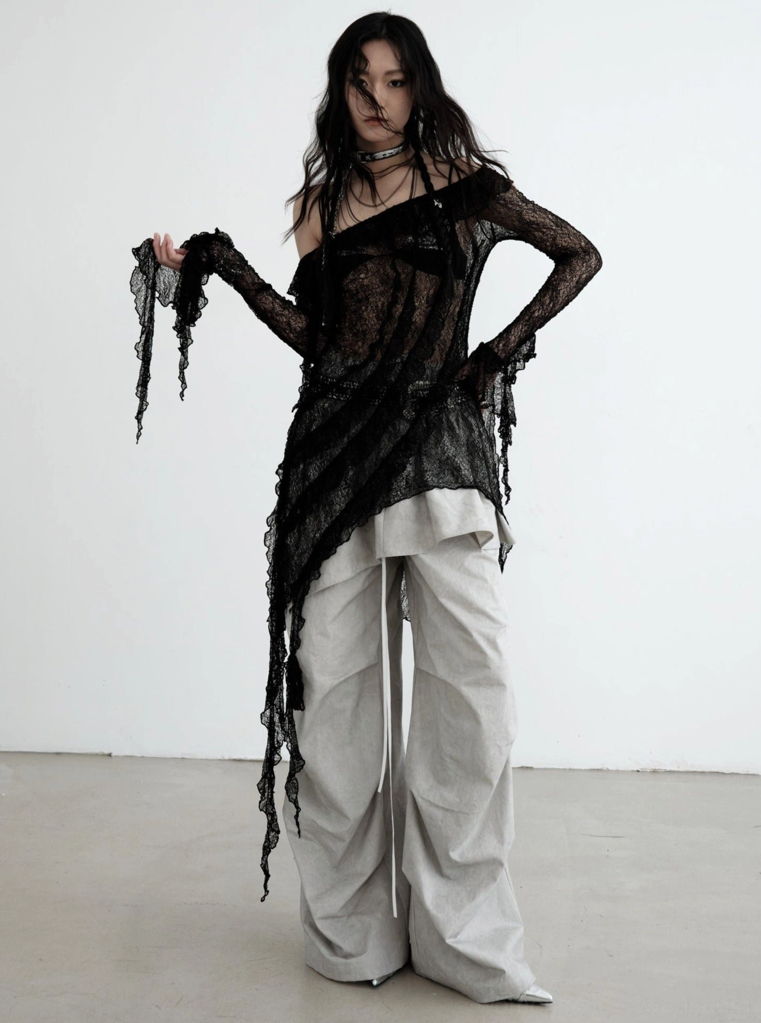 Gray ruffled palazzo cargo pants paired with a sheer black lace top, layered chokers, and avant-garde East Asian streetwear styling