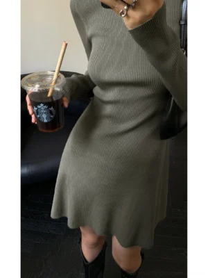 Close-up of gray sage green ribbed knit turtleneck mini dress showing fitted bodice and flared hem texture