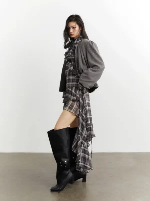 Side view of gray stardust cropped balloon sleeve streetwear jacket styled with a plaid ruffle dress and black over-the-knee boots