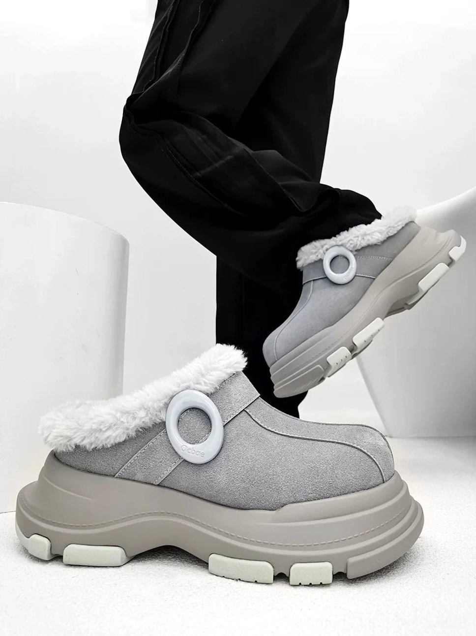 Gray suede-finish fleece-lined platform clog shown in side profile with circular ring accent, rounded toe, and chunky anti-slip outsole
