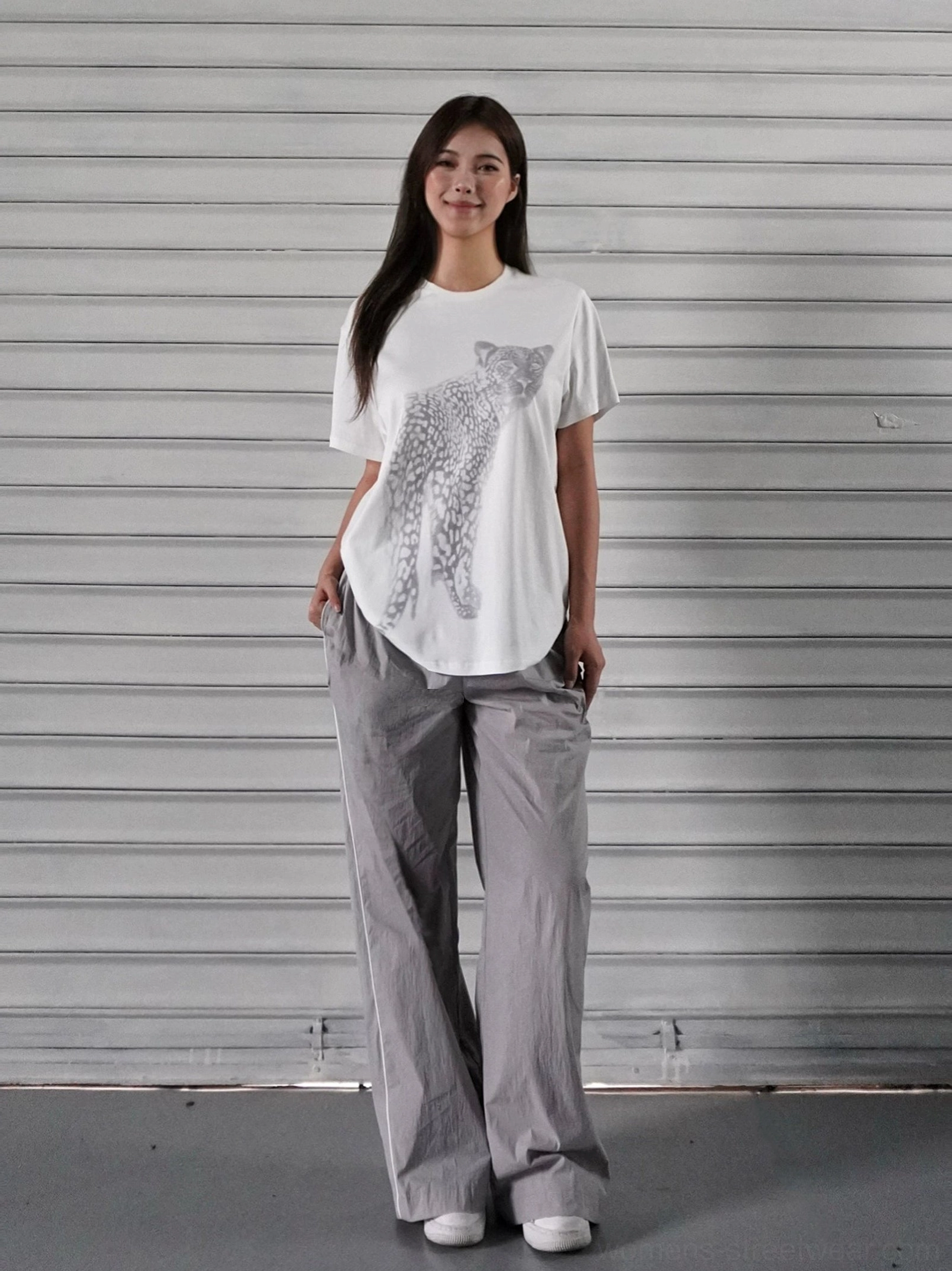 Gray wide-leg athletic cargo pants styled with a white leopard print cropped T-shirt in urban streetwear fashion