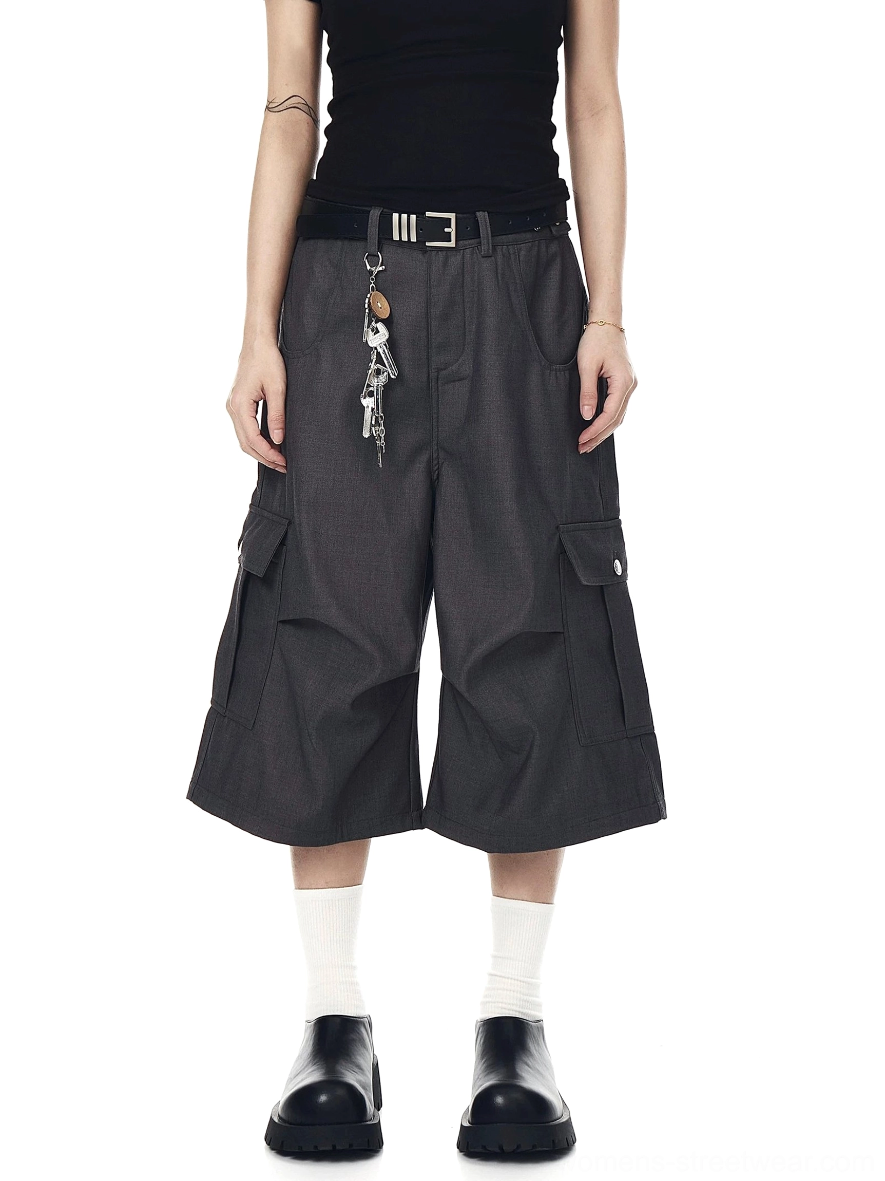 Dark gray wide-leg cargo culotte shorts styled with a cropped tank, leather loafers, utility belt, and keychain detail