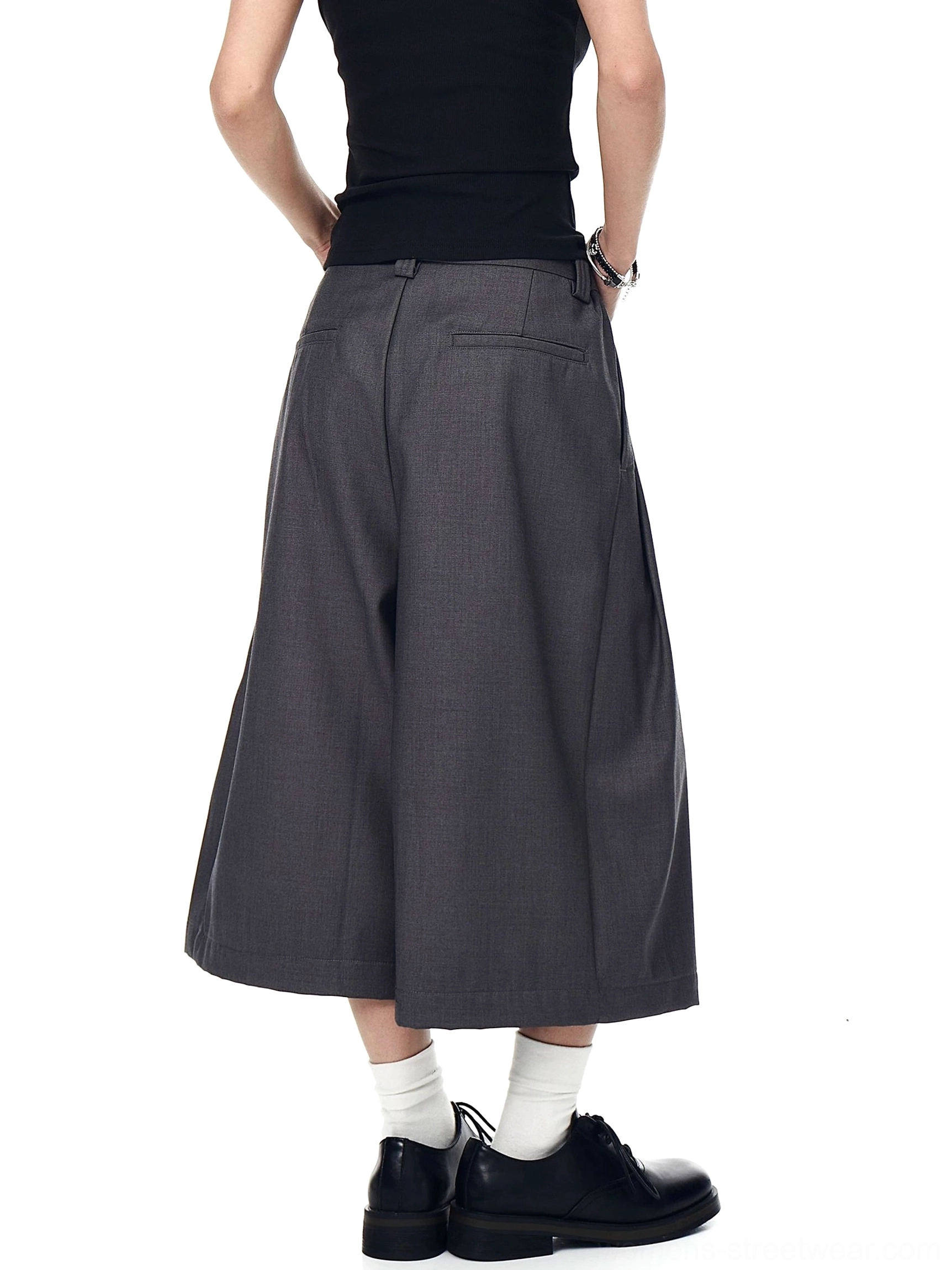 Gray wide-leg cropped pleated trousers shown from the back with elasticated waistband, back pocket, and smooth tailored fabric