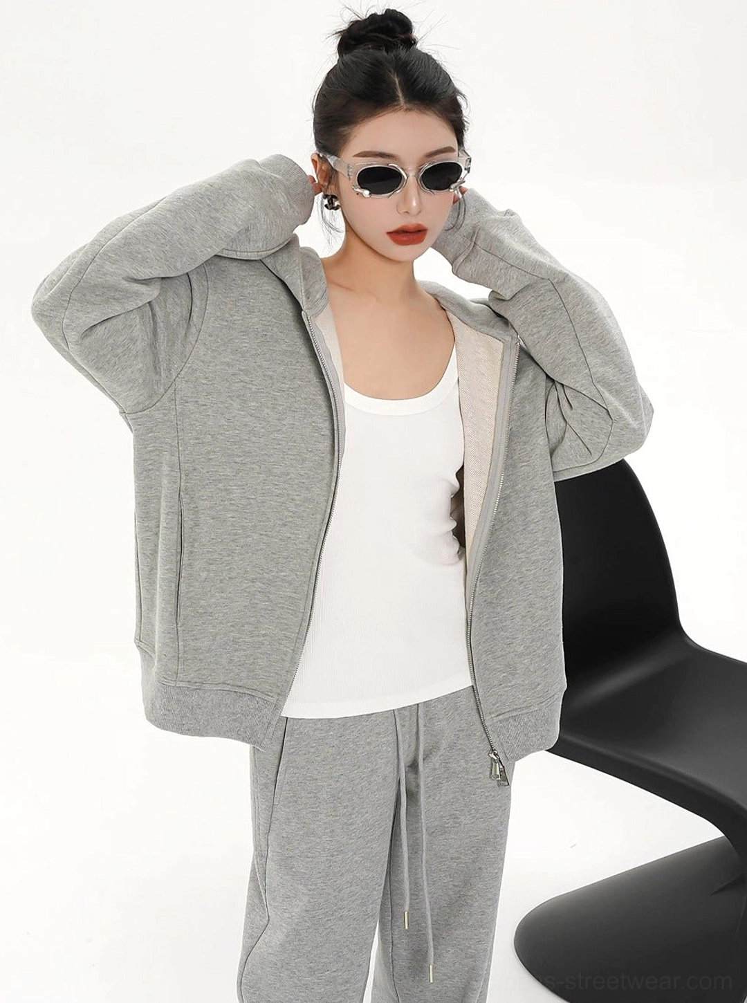 Women's relaxed gray zip-up hoodie jacket worn open over a white tank top in casual Seoul streetwear styling