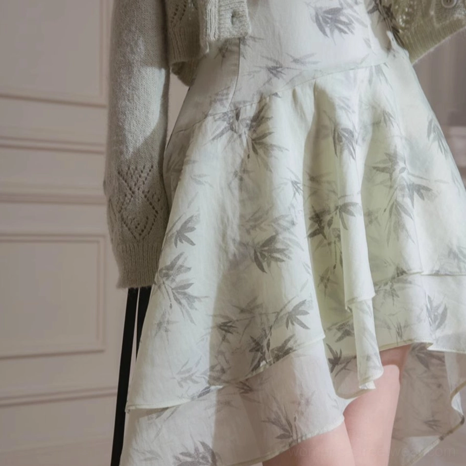 Close up detail of flowing green bamboo print halter dress with double layered asymmetric chiffon ruffle hem