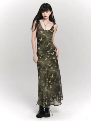 Front view of green camo butterfly print spaghetti strap maxi dress styled with a long silver pendant necklace