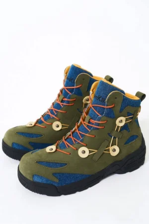Green denim outdoor hiking boots shown in a three quarter front view with olive suede panels orange laces beige decorative buckles and rugged black anti slip outsole