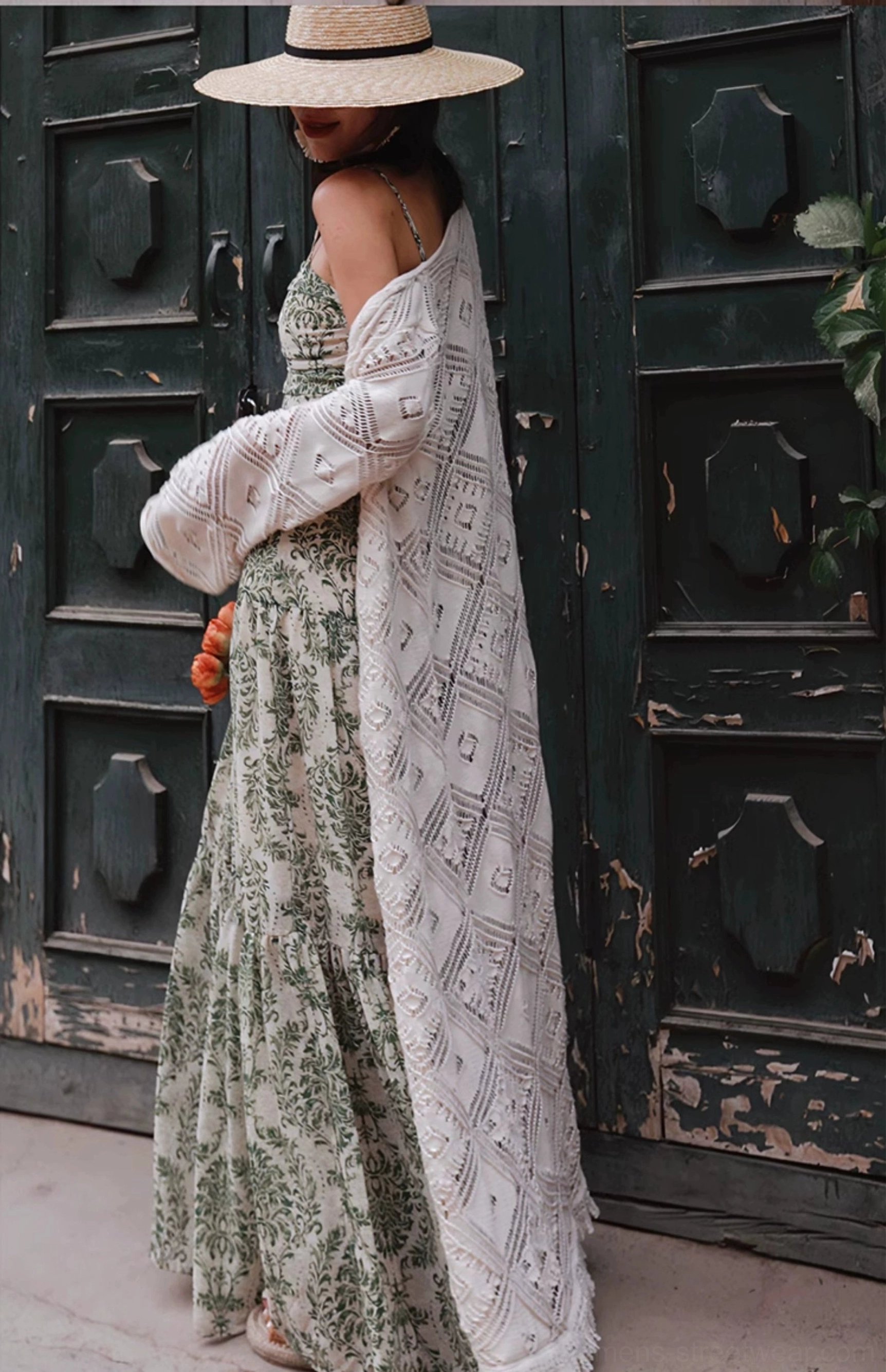 Side view of green floral ruched bodice maxi dress with tiered skirt styled with a loose white cardigan