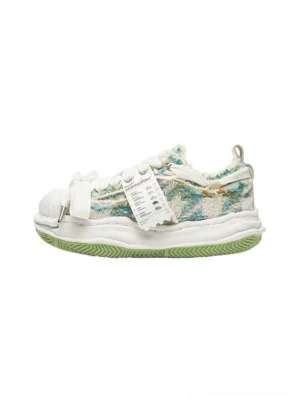Green frayed tweed platform sneakers shown from the left side with layered textile panels, oversized cream laces, rounded shell toe, thick sculpted white midsole, and lime green rubber outsole