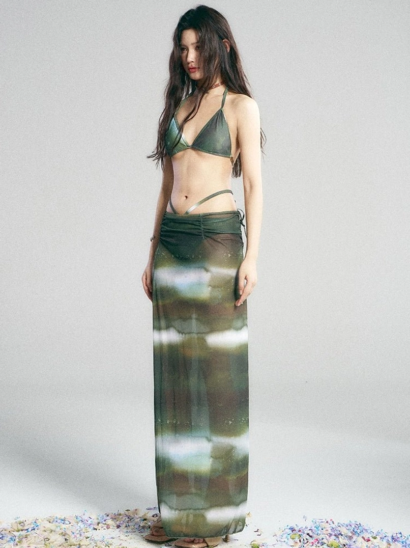 Back three quarter view of green galaxy print bikini set with sheer full length maxi skirt and exposed back halter top