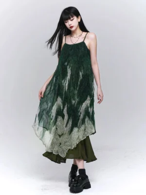 Green ombre tie-dye layered maxi slip dress shown from a left three-quarter angle with crinkled fabric, thin spaghetti straps, asymmetrical hem, and olive green underlayer