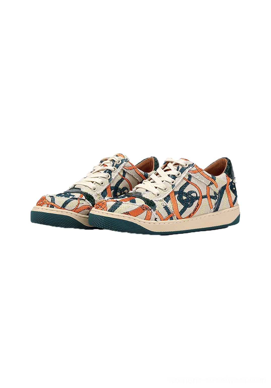 Pair of green sole graffiti canvas low-top streetwear sneakers shown from the front three-quarter angle