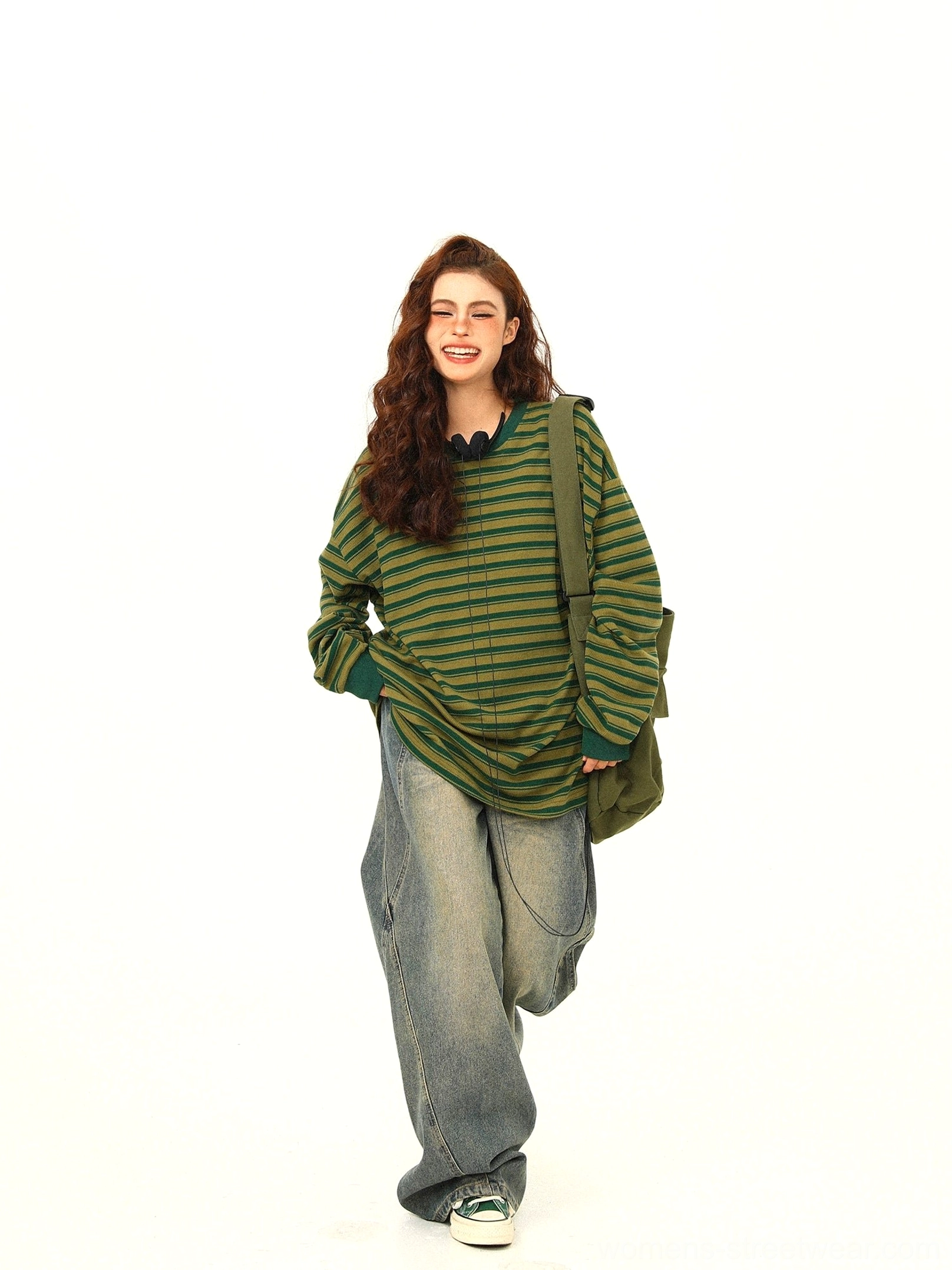 Green and yellow striped oversized drawstring long sleeve streetwear tee front view styled with wide leg jeans and sneakers