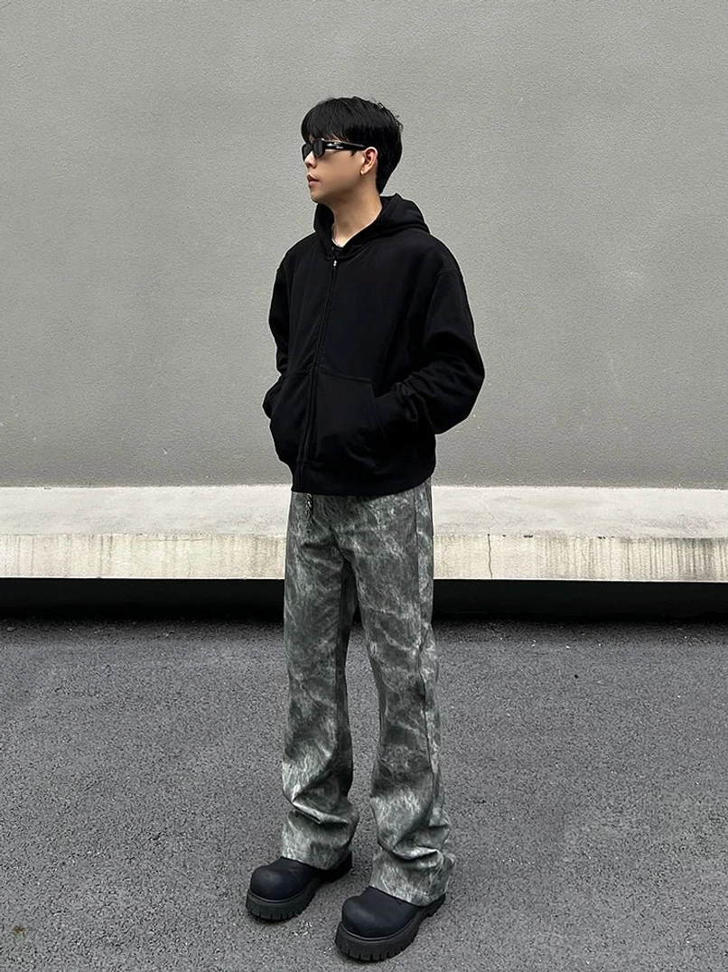 Full side view of grey acid wash marble flared jeans paired with a black hoodie in an urban Seoul streetwear outfit