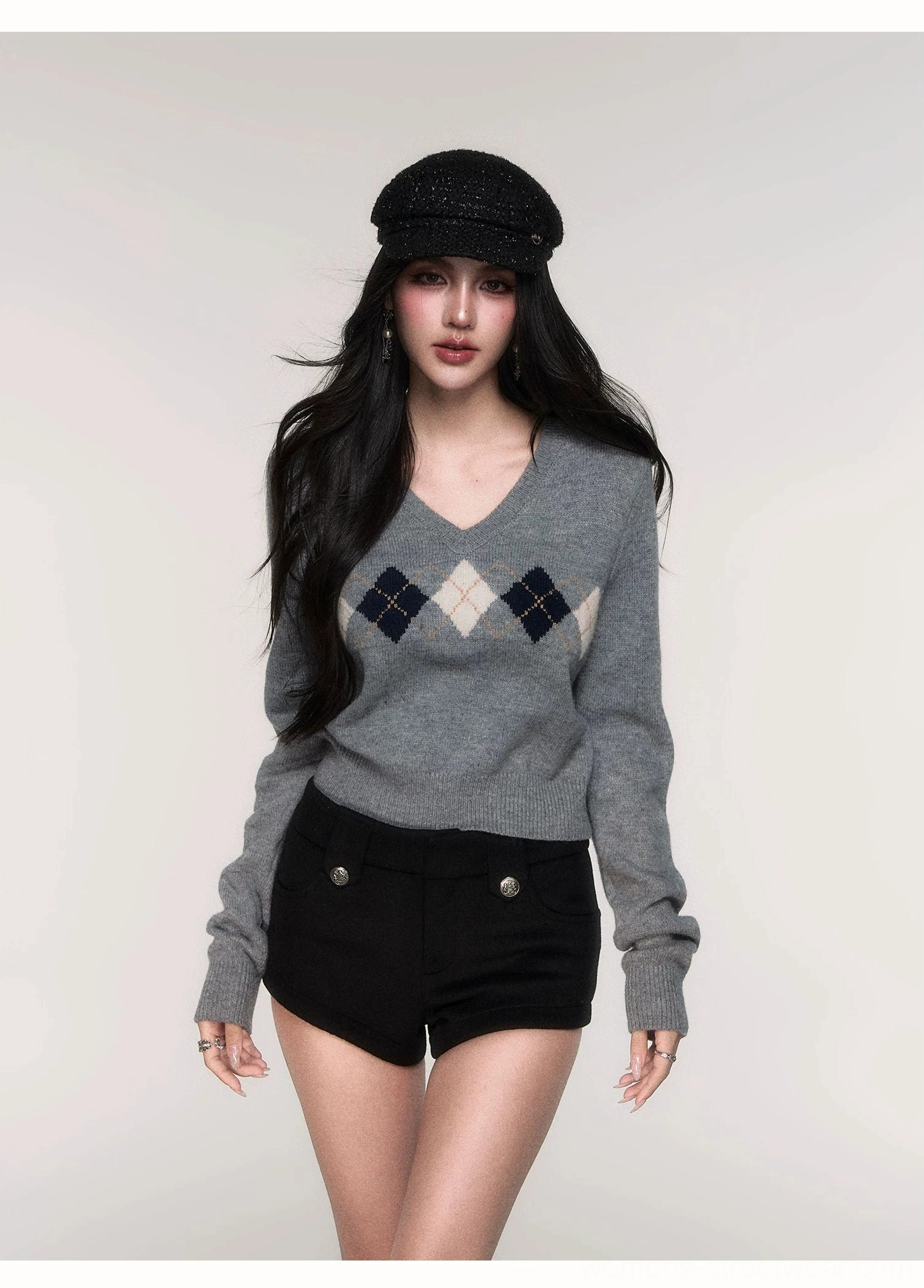 Front view of women's grey argyle cropped knit sweater with navy and cream diamond pattern and V-neckline